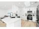 Modern kitchen featuring white cabinets, stainless steel appliances, and a bright skylight, perfect for cooking at 5431 Landis Ave, Port Orange, FL 32127