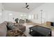 Bright living room with modern ceiling fan, neutral decor, and ample natural light from arched windows at 5431 Landis Ave, Port Orange, FL 32127