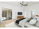 Main bedroom with a ceiling fan, television, light hardwood floors and a sliding glass doors to the outside at 5431 Landis Ave, Port Orange, FL 32127