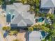 Aerial view of a large home with a gray roof, pool, and lush tropical landscaping at 604 S Atlantic Ave, New Smyrna Beach, FL 32169