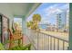 Charming covered balcony with colorful chairs offering views of palm trees and the street at 604 S Atlantic Ave, New Smyrna Beach, FL 32169