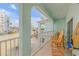 Inviting covered balcony with chairs offering views of the street and blue sky at 604 S Atlantic Ave, New Smyrna Beach, FL 32169