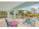 Charming balcony with seating overlooks a pool and lush tropical landscaping at 604 S Atlantic Ave, New Smyrna Beach, FL 32169