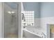 Bathroom with a whirlpool tub, glass block window, and separate shower at 604 S Atlantic Ave, New Smyrna Beach, FL 32169