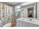 Cozy bathroom with white vanity, patterned shower curtain, and neutral gray walls at 604 S Atlantic Ave, New Smyrna Beach, FL 32169