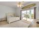 Cozy bedroom features a private balcony, ceiling fan, and neutral decor with beachy accents at 604 S Atlantic Ave, New Smyrna Beach, FL 32169