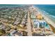 A high-angle view of a coastal neighborhood featuring city buildings, residential houses, and a sandy beach at 604 S Atlantic Ave, New Smyrna Beach, FL 32169