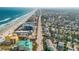 An expansive coastal community with varied buildings, a wide beach, and a blue ocean at 604 S Atlantic Ave, New Smyrna Beach, FL 32169