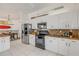 Well-equipped kitchen with modern appliances, white cabinetry, and tiled flooring near the dining area at 604 S Atlantic Ave, New Smyrna Beach, FL 32169