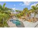 Aerial view of a backyard pool surrounded by lush palm trees and tropical plants at 604 S Atlantic Ave, New Smyrna Beach, FL 32169