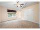 Bright, carpeted bedroom with a ceiling fan, window, and spacious closet at 634 Coral Trace Blvd, Edgewater, FL 32132