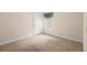 A neutral carpeted bedroom features a window with blinds and a white paneled door at 634 Coral Trace Blvd, Edgewater, FL 32132
