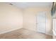 A neutral carpeted bedroom features a window with blinds and a white paneled door at 634 Coral Trace Blvd, Edgewater, FL 32132