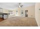 Open-concept living room featuring carpeted floors, a ceiling fan, and natural light at 634 Coral Trace Blvd, Edgewater, FL 32132