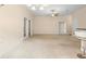 Spacious living room featuring neutral carpet, ceiling fan, and ample natural light at 634 Coral Trace Blvd, Edgewater, FL 32132