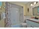 Well-lit bathroom with a shower-tub combination, decorative surfboard, and seashell-themed decor at 6443 Engram Rd, New Smyrna Beach, FL 32169