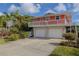 Charming exterior of a raised beach house featuring a two-car garage and ample parking at 6443 Engram Rd, New Smyrna Beach, FL 32169