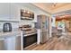 Stainless steel appliances, white cabinets, and wood look floors in this modern kitchen at 6443 Engram Rd, New Smyrna Beach, FL 32169