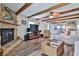 Spacious living room features a stone fireplace, ceiling fan, and wood beams under a white ceiling at 6443 Engram Rd, New Smyrna Beach, FL 32169