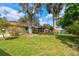 Large backyard showcasing mature trees, a screened patio, and a storage shed at 704 Hillville Dr, Port Orange, FL 32127