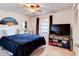 Cozy bedroom featuring a ceiling fan, window, and TV on a wooden stand at 704 Hillville Dr, Port Orange, FL 32127