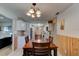 Dining room features classic table, wood paneling, and chandelier-style light fixture at 704 Hillville Dr, Port Orange, FL 32127