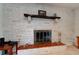 Living room fireplace with brick surround and dark wood mantel, adding warmth and character to the space at 704 Hillville Dr, Port Orange, FL 32127