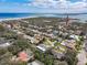 A high aerial view of a neighborhood with various house styles and the lighthouse by the water in the distance at 86 Rains Ct, Ponce Inlet, FL 32127