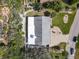 An aerial view of a home with a dark roof and a light patio with lush landscaping and a brick driveway at 86 Rains Ct, Ponce Inlet, FL 32127