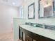 Stylish bathroom with a double sink vanity, decorative mirrors, and a glass backsplash at 86 Rains Ct, Ponce Inlet, FL 32127