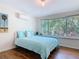 Cozy bedroom with a queen-size bed, light blue bedding, and large windows with green views at 86 Rains Ct, Ponce Inlet, FL 32127