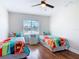 This cozy bedroom features two twin beds, a ceiling fan, and wood laminate floors at 86 Rains Ct, Ponce Inlet, FL 32127