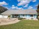 Charming single-story home featuring beautiful landscaping, light blue exterior paint, and inviting front porch swing at 86 Rains Ct, Ponce Inlet, FL 32127