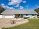 Charming home with a light blue exterior, two car garage, brick driveway and beautiful front yard landscaping at 86 Rains Ct, Ponce Inlet, FL 32127