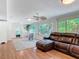 Spacious living room featuring a brown leather sofa, a dining table, and large windows at 86 Rains Ct, Ponce Inlet, FL 32127