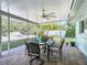 Relaxing screened patio featuring brick pavers and a dining area with a ceiling fan at 86 Rains Ct, Ponce Inlet, FL 32127