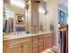 The bathroom features a double sink vanity with light wood cabinets, a travertine countertop, and modern fixtures at 905 Maple St, New Smyrna Beach, FL 32169