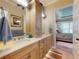 This bathroom has a dual sink vanity with framed mirrors and a view into the attached main bedroom at 905 Maple St, New Smyrna Beach, FL 32169