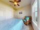 Cozy bedroom with a ceiling fan, window, wicker chair and decorative accents at 905 Maple St, New Smyrna Beach, FL 32169