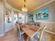 Bright dining room with wood floors, neutral walls, stylish furniture, and coastal-themed decor at 905 Maple St, New Smyrna Beach, FL 32169