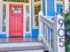 Charming home featuring a bright red front door and the house number on a white post at 905 Maple St, New Smyrna Beach, FL 32169