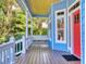 Inviting front porch with swing, blue siding, and natural light filtering through lush greenery at 905 Maple St, New Smyrna Beach, FL 32169