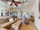 Bright living room featuring hardwood floors, coffered ceiling, ceiling fan, and open floor plan to the kitchen at 905 Maple St, New Smyrna Beach, FL 32169