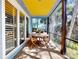 Relaxing screened patio featuring a wooden table with seating for four and a bright yellow ceiling at 905 Maple St, New Smyrna Beach, FL 32169