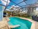 A fenced-in pool with an attached lounge area, a BBQ grill, and access to lush greenery at 905 Maple St, New Smyrna Beach, FL 32169