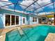 A beautiful screened pool with a ramp for entering, convenient access to the main house and an outdoor lounge area at 905 Maple St, New Smyrna Beach, FL 32169