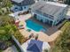 Aerial view of the backyard featuring a pool, spa, outdoor seating, and lush landscaping at 910 Maple St # A & B, New Smyrna Beach, FL 32169