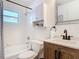 White tiled bathroom with wood vanity and shower and tub combo at 910 Maple St # A & B, New Smyrna Beach, FL 32169