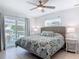 Comfortable bedroom features a ceiling fan, an exterior balcony and light wood flooring at 910 Maple St # A & B, New Smyrna Beach, FL 32169