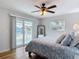 Bedroom with queen-sized bed, ceiling fan, and sliding glass doors to balcony at 910 Maple St # A & B, New Smyrna Beach, FL 32169